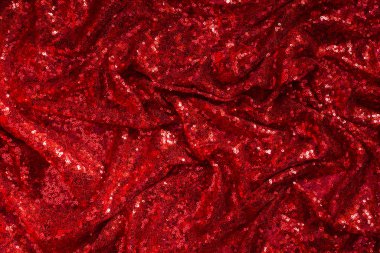 Parlak kırmızı pliat kumaş zemin olarak kaplanmış.