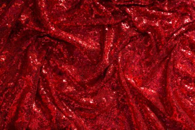 Parlak kırmızı pliat kumaş zemin olarak kaplanmış.