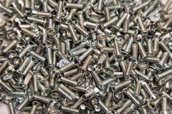 M6 metal screws galvanized white in bulk closeup in the studio