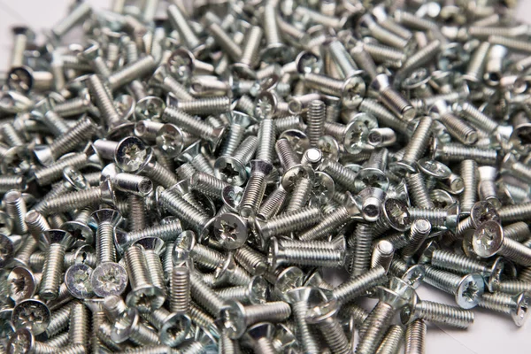 M6 metal screws galvanized white in bulk closeup in the studio