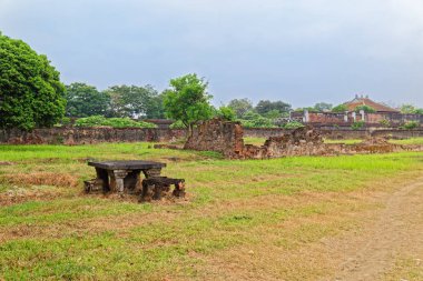 Hue, Vietnam 'daki Mor Yasak Şehir' in (İmparatorluk Şehri) iç avlusunda yıkılmış tuğla duvara karşı eski taş masa