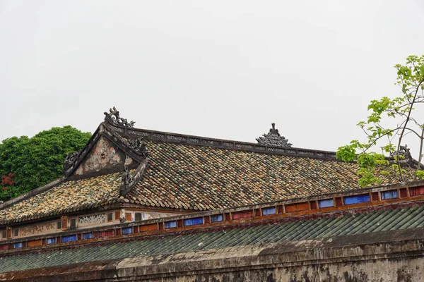 Traditionelle Dekorationen auf dem Indochina-Dach des Tempels in violett verbotene Stadt in Farbton, Vietnam — Stockfoto