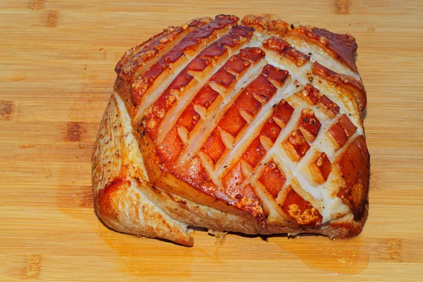Assado de porco com crepitação em tábua de madeira, pronto para comer — Fotografia de Stock