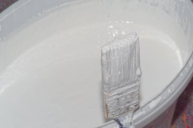 Beyaz duvar boyalı boya fırçası ve kovaya yakın çekim