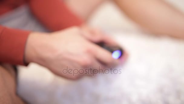 Pessoas com um controlador nas mãos a jogar consola de jogos de vídeo . — Vídeo de Stock