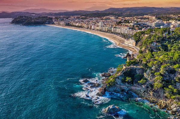 Costa Brava 'da yer alan İspanyol tatil beldesi Lloret de Mar Katalonya' nın bir kıyı bölgesidir. Hava görüntüsü. Sant Joan Kalesi, deniz, gün batımı.