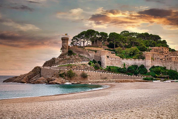 A cidade espanhola de Tossa de Mar, localizada na Costa Brava, é uma região costeira da Catalunha. Céu de pôr do sol bonito, um forte de precipício antigo, praia arenosa e o Mar Mediterrâneo . — Fotografia de Stock