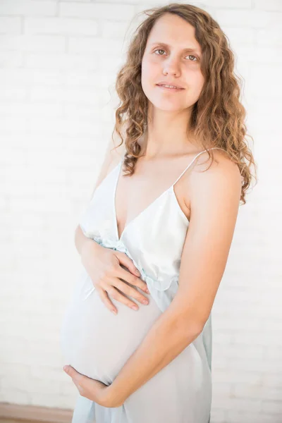 Gravidez, maternidade, pessoas e conceito de expectativa - close-up de mulher grávida feliz com barriga grande na janela — Fotografia de Stock