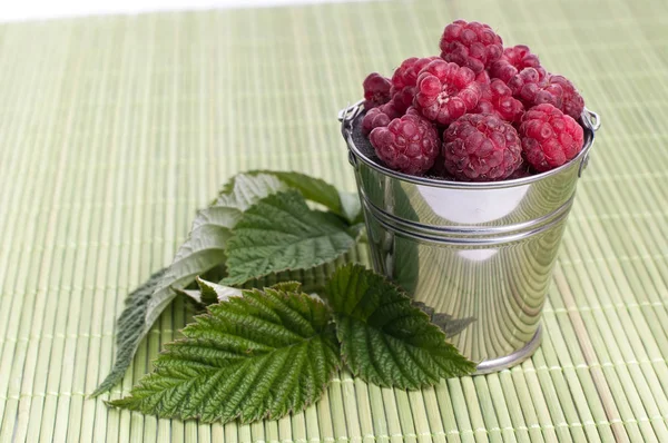 Photo of fresh raspberries inside a bowl with mint on wooden table — Stock Photo, Image