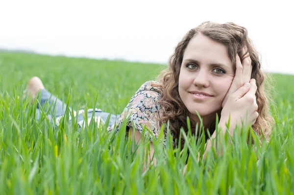 Portrait of romantic, young woman with short hair lying on green grass, dreams — Stock Photo, Image