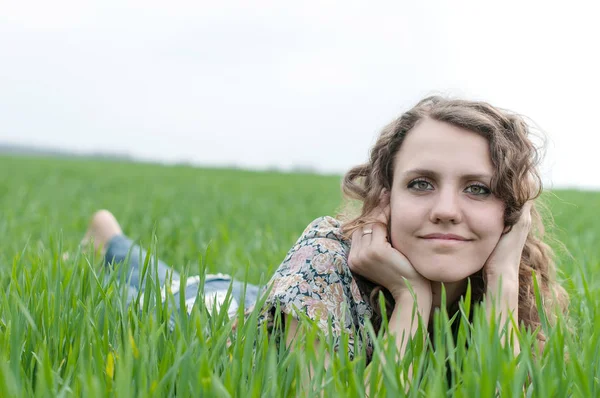 Porträtt av romantiska, unga kvinnan med kort hår liggande på grönt gräs, drömmar — Stockfoto