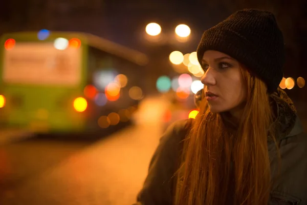 Young beautiful girl catches a taxi in the city street at night — Stock Photo, Image