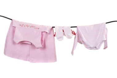 Beyaz arka plan üzerinde izole bir ip üzerinde kurutma bebek giysileri.