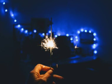 Bengal ışığı elinde mavi Noel ışığı ve yeni yıl karanlık tatil geçmişi