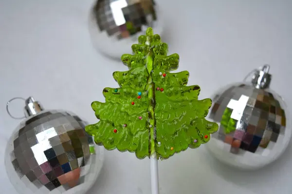 Χριστουγεννιάτικο Πράσινο Δέντρο Γλειφιτζούρι Καραμέλα Στο Χέρι Και Μπάλες Λευκό — Φωτογραφία Αρχείου