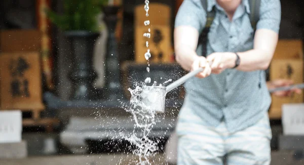 Turista em purificação de água na entrada de templo japonês — Fotografia de Stock