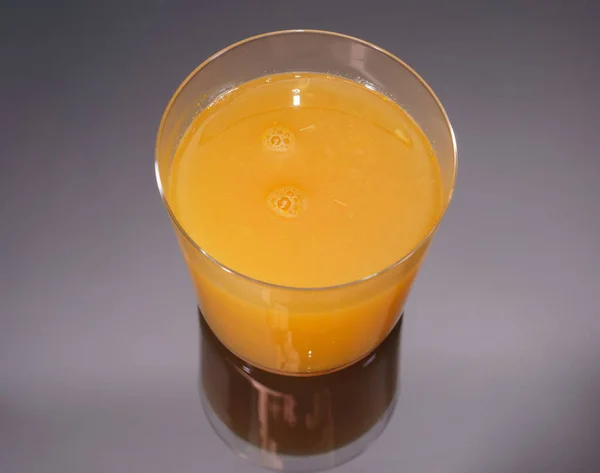 Top view of orange juice over black and glass reflection — Stock Photo, Image