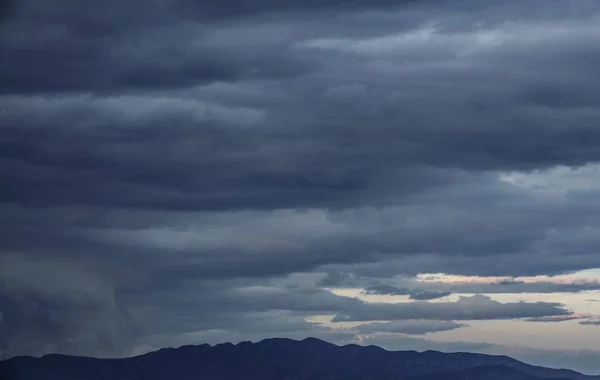 Cloudy sky, dark clouds, close storm over mountain range — Stock Photo, Image