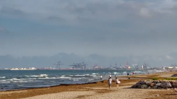 Poort met kranen, strand en wazig mensen time-lapse — Stockvideo