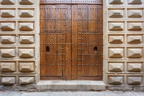 Old wooden door in stone facade — Stock Photo, Image