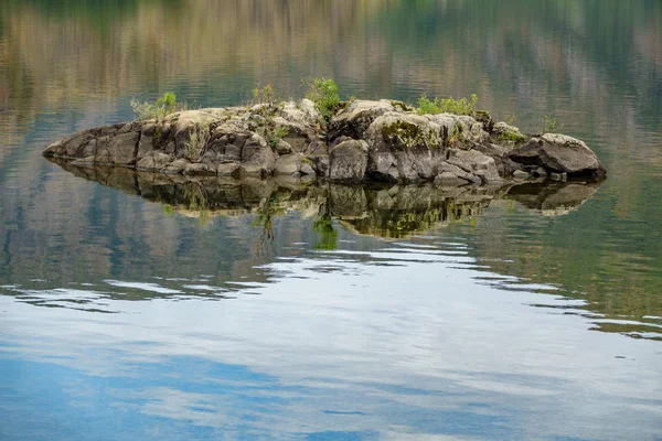 Tiny rock mitt i en sjö — Stockfoto