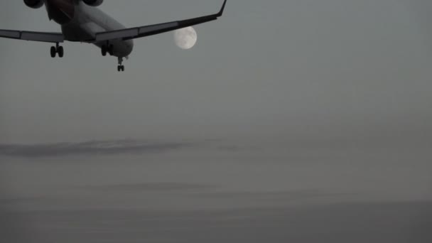 Jet aterrizaje al atardecer contra la luna llena, cámara lenta — Vídeos de Stock