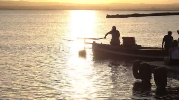 Západ slunce nad jezerem s podsvícením turistické lodi poblíž pier — Stock video