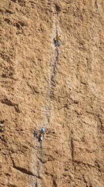 Erkek dağcılar tarafından üst üste bir uçurum asılı