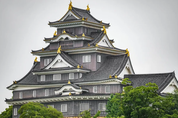 Toppen av Okayama slott fasad mot vit himmel — Stockfoto