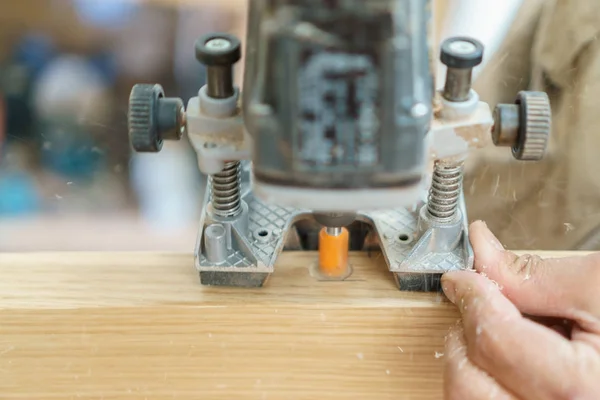 Carpenter hand and machine working, preparing door for hinges — Stock Photo, Image