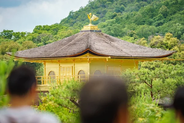 Top of golden pavilion with blurred tourist heads — Stock Photo, Image