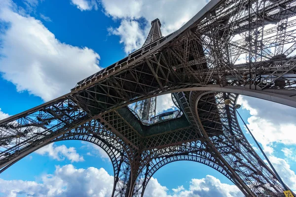 Az Eiffel-torony alsó nézet lábak, kék ég alatt — Stock Fotó