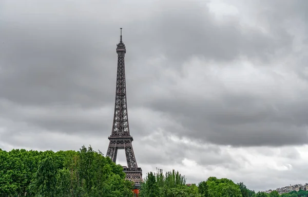 Eiffelova věž nad stromy s bouřlivých mračen — Stock fotografie