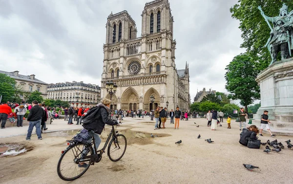 PARÍS, FRANCIA - 15 DE MAYO DE 2015: Paseos turísticos no identificados en bicicleta cerca de la catedral de Notre Dame con muchos turistas en París, España — Foto de Stock