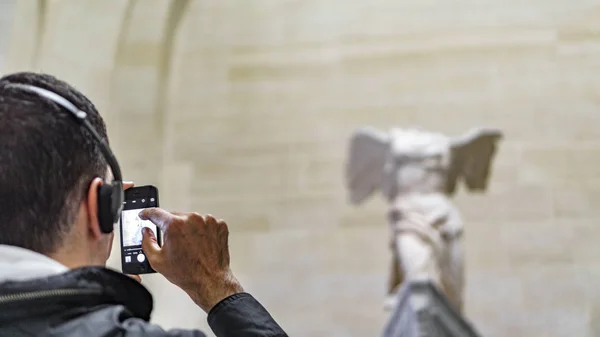 PARÍS - 16 DE MAYO: Turista no identificado tomando fotos a Venus de Milo en el Museo del Louvre el 16 de mayo de 2015 París, Francia. Louvre es el museo más grande de París — Foto de Stock