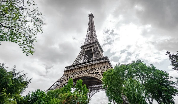 Bottom of Eiffel Tower with trees — Stock Photo, Image