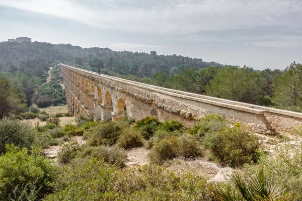 The Ferreres Aqueduct profile view with tourist walking — Stock Photo, Image