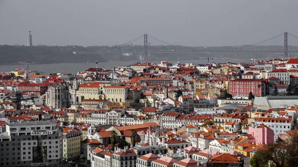 Telhados com a ponte a criar uma linha no horizonte de Lisboa — Fotografia de Stock