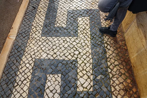 Calçada de pedra de Lisboa com pés de mulher de pé — Fotografia de Stock