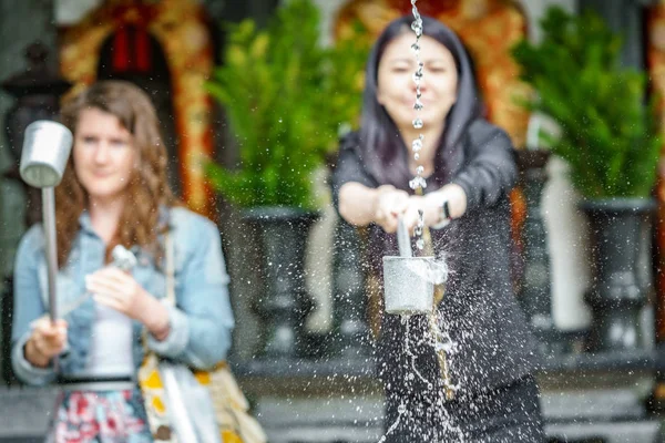 KYOTO- 8 JUIN : Un touriste non identifié prend de l'eau pour la purification à l'entrée du temple japonais à Kyoto le 8 juin 2015 — Photo