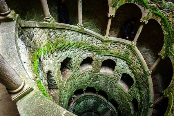 Il modello del pozzo di iniziazione con due turisti sfocati che scendono — Foto Stock