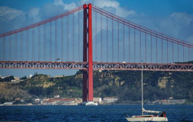 Long shot of 25 de Abril Bridge in Lisbon with sailing boat clipart