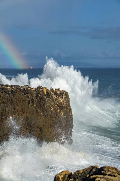 Vagues sauvages se brisant sur la falaise avec arc-en-ciel — Photo