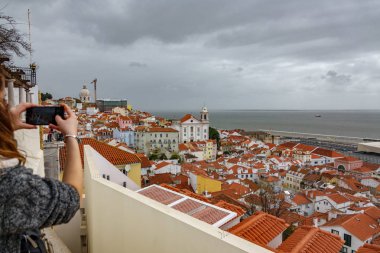 Alfama mahalle cep telefonuyla fotoğrafını çekmek turist