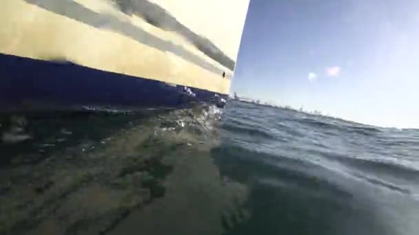 Zeilboot boeg zeilen met commerciële haven op de achtergrond — Stockvideo