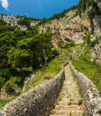 Uçuruma doğru adımlar, mavi gökyüzünün altındaki alt manzara