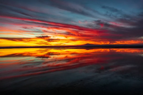 Tramonto con riflesso del paesaggio nuvoloso nella laguna di Chaxa, Atacama — Foto Stock