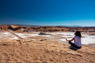 Mavi gökyüzüne karşı ay vadisinde Yoga, Atacama