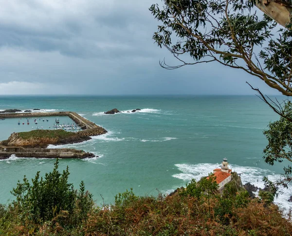 Lighthouse and marina under stormy cloudy sky — Stock Photo, Image