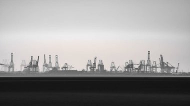 Ufukta vinçli ticari port silueti, uzun pozlama